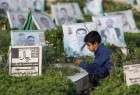 A Yemeni child sits next to the grave of a loved one in a cemetery in the capital Sanaa on the first day of Eid (AFP)