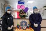 Two Iranian nurses in coronavirus-infection ward, standing next to Haft Seen set, traditional set of items laid to mark beginning of the Persian New Year as the country is challenged by COVID-19 on the eve of the New Year 1399. (Photo: Tasnim)