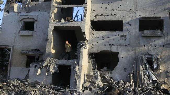 A Palestinian man inspects a damaged building following overnight Israeli airstrikes on the town of Khan Yunis, in the southern Gaza Strip on November 20, 2012.