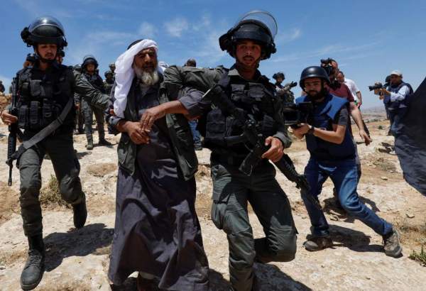 Israeli troops move away an elderly Palestinian man during a protest on 20 May 2022 after Israel