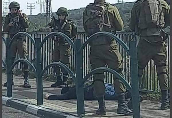 Israeli occupation forces looking at a Palestinian they have shot and killed in the West Bank.