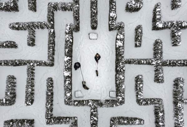 FILE PHOTO: People walk with their dogs through a snow-covered garden maze in Gelsenkirchen, Germany, Wednesday, Feb. 10, 2021 ©  AP / Martin Meissner