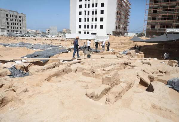 Archaeologists work on findings as a lead sarcophagus uncovered during archaeological excavations at the site of Roman necropolis in the north of Gaza Strip, the second such discovery this year on July 16, 2023 [Mustafa Hassona – Anadolu Agency]